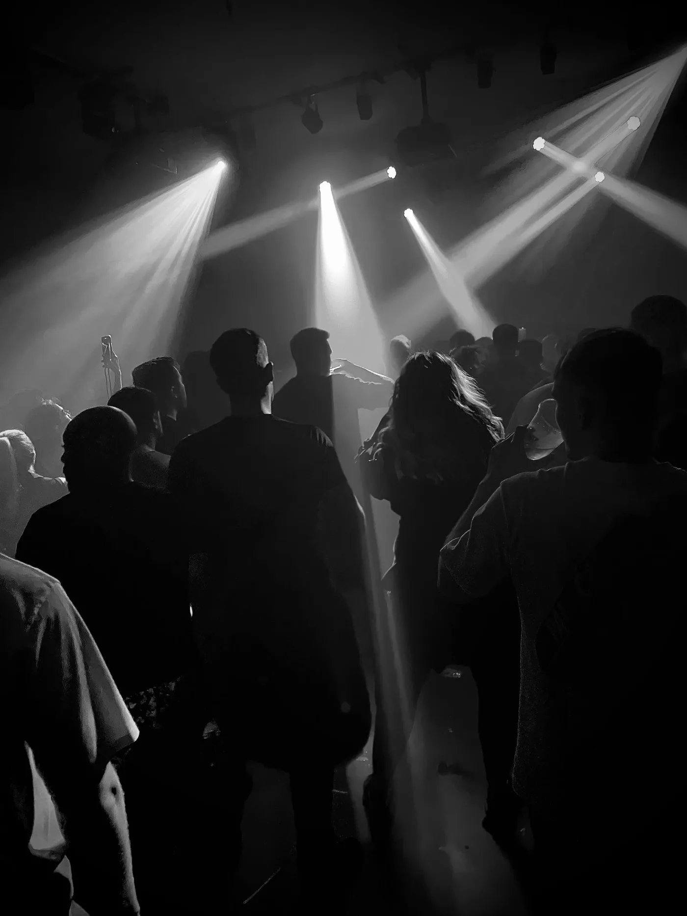 A crowded nightclub dance floor under stage lighting